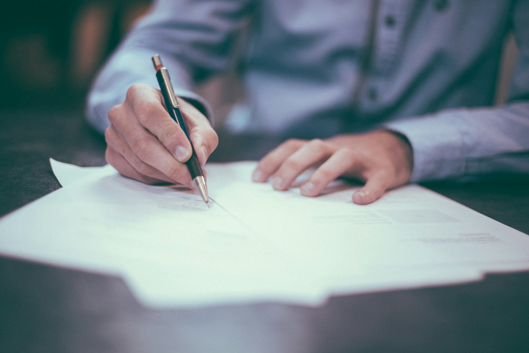 Close-up of a professional reviewing and signing documents